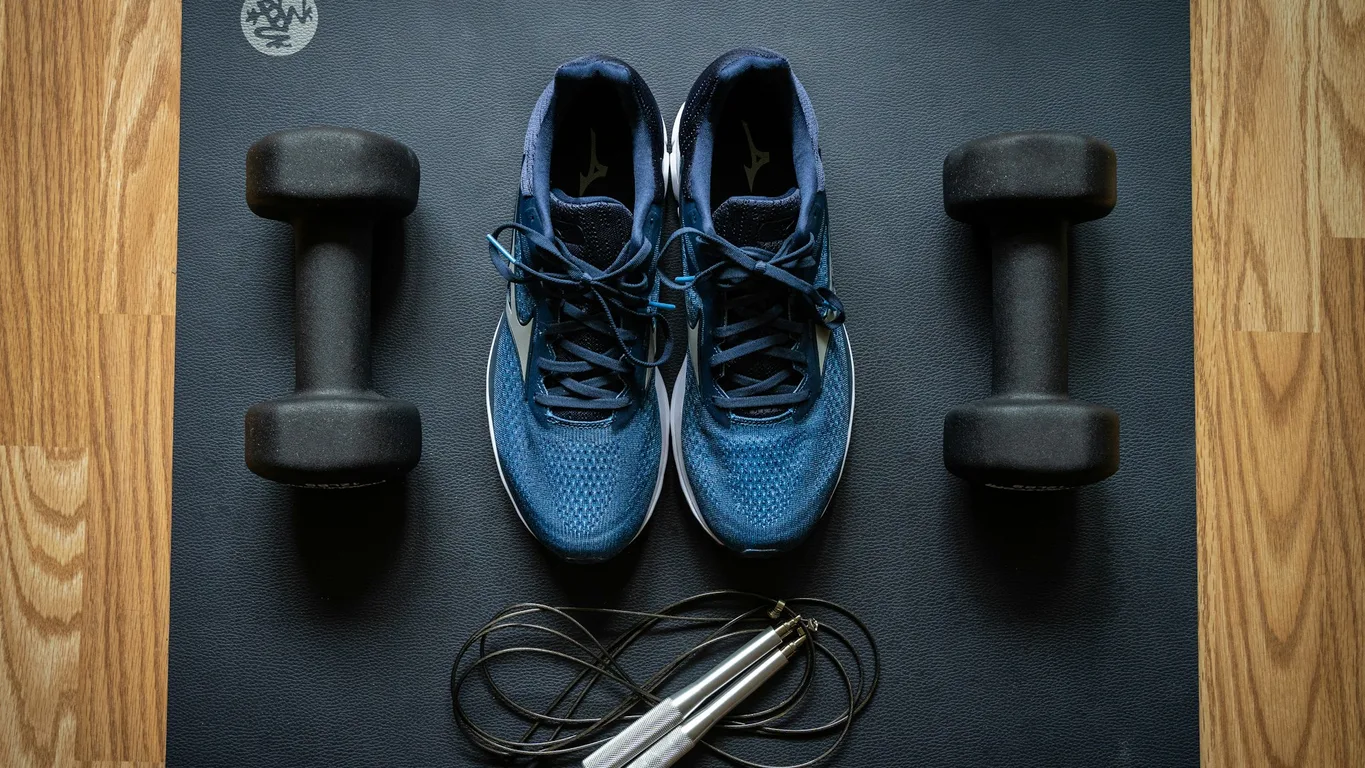 Running shoes and kettlebell side by side on a gym floor, seen from above