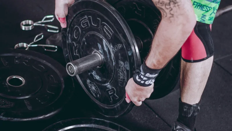 Homme effectuant un soulevé de terre lourd avec une barre dans une salle de sport