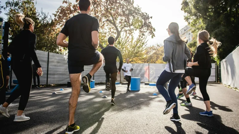 Femme qui s'échauffe au squat avec une barre vide dans une salle de sport