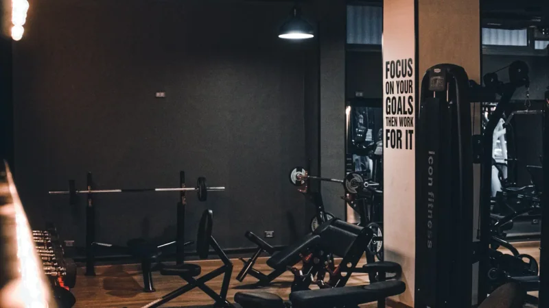 Man performing a single-arm dumbbell row on a flat bench in the gym