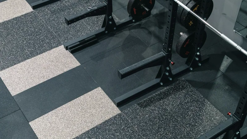 Homme effectuant un rowing à la poulie, vu de profil dans une salle de sport