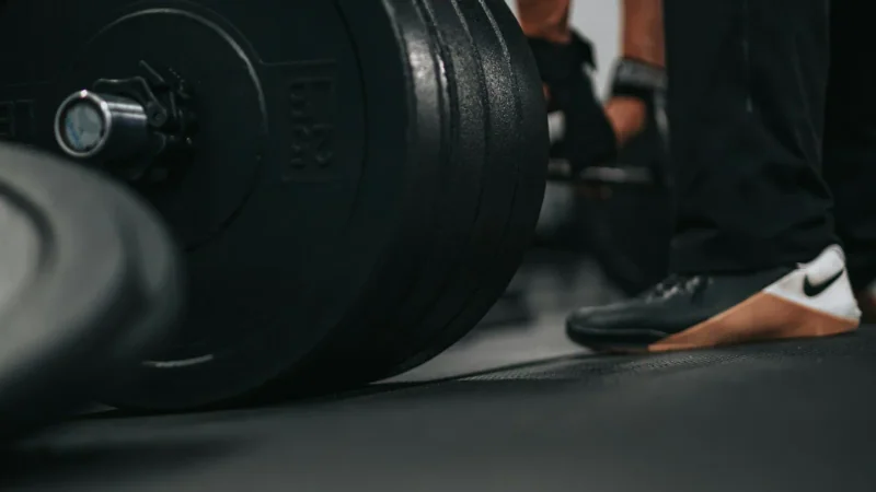 Mains couvertes de magnésie frappées l’une contre l’autre dans la lumière chaude d’une salle de sport