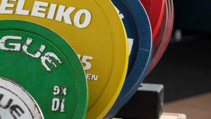 Gros plan de disques de musculation colorés sur un support.