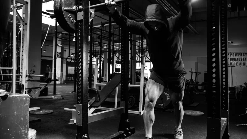 Pratiquant de musculation se concentrant près d’un rack avant une série lourde